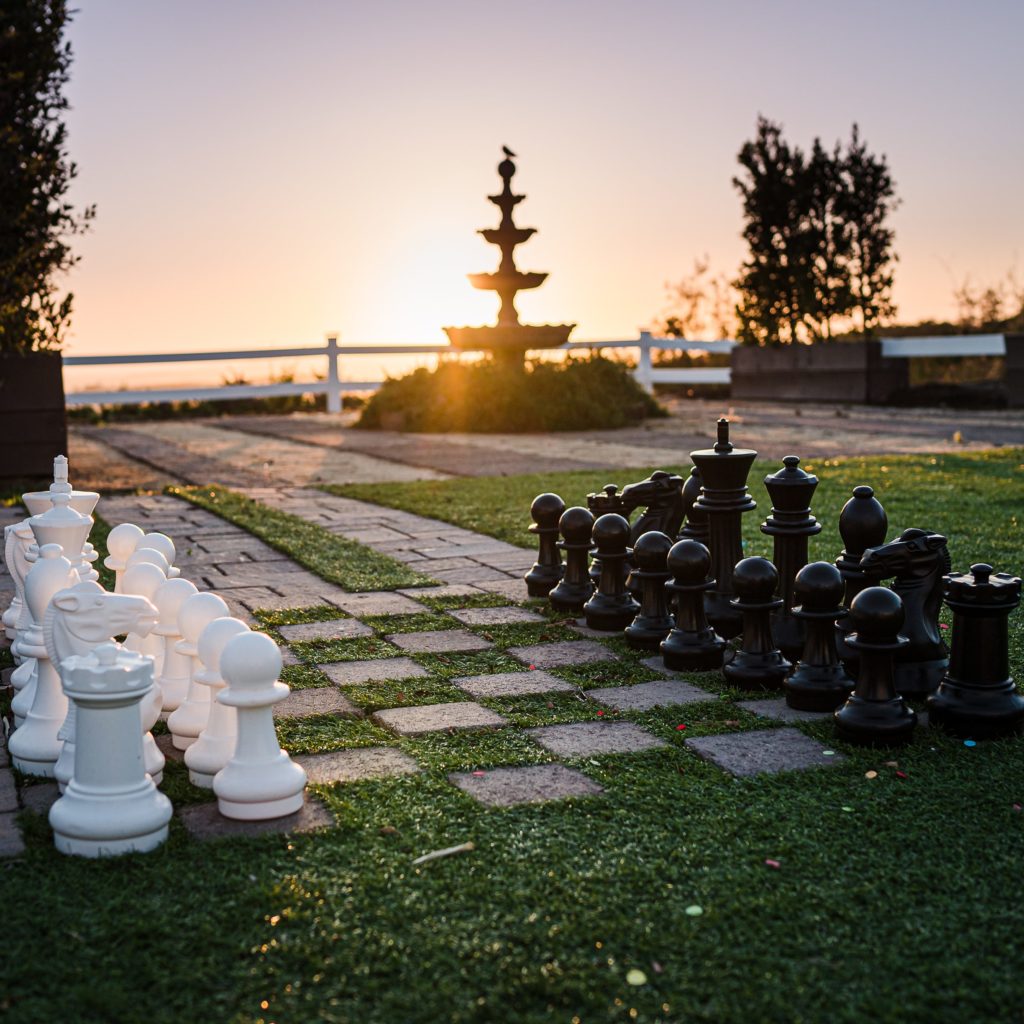 Backyard wedding reception with long wooden table by San Diego Backyard Rentals